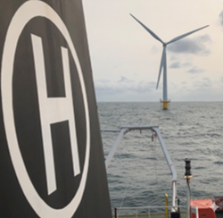 Helideck with offshore wind turbine in background